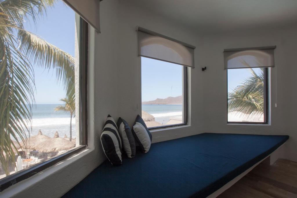 a room with two windows and a couch with pillows at Gaviana Resort in Mazatlán