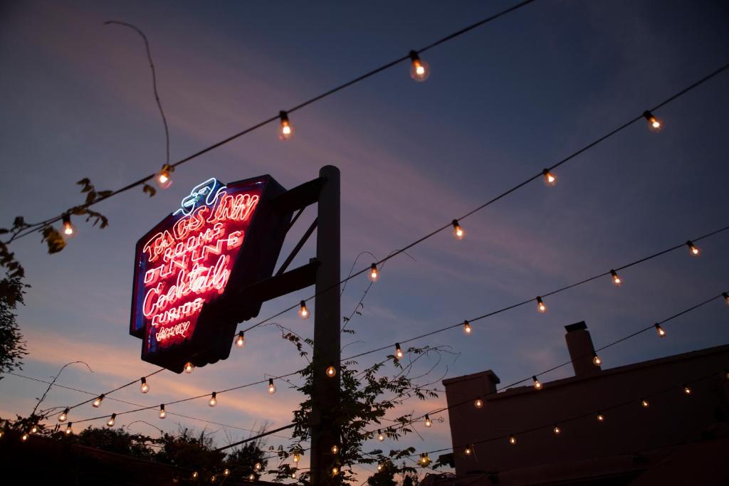 a neon sign hanging from a string with lights at The Historic Taos Inn in Taos