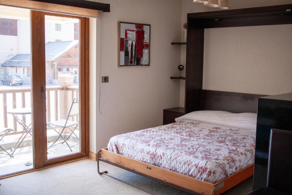 ein Schlafzimmer mit einem Bett und einem Balkon in der Unterkunft 6PAX Edificio Valle Cóndores SKI OUT Valle Nevado Servicio HOM in Santiago