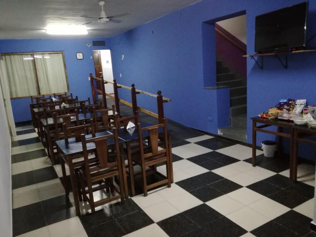 La Nueva Estancia في سانتا روزا: غرفة طعام مع طاولة وكراسي وجدار أزرق