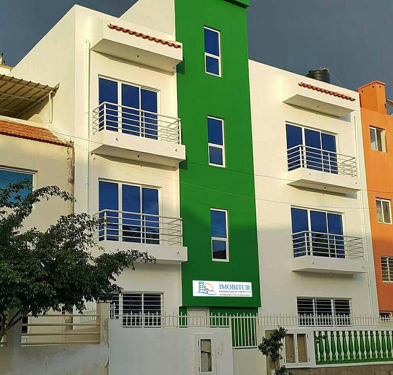 a building with a green and white at IMOBITUR-Tourist Apartments- Palmarejo Centro AV SV in Praia