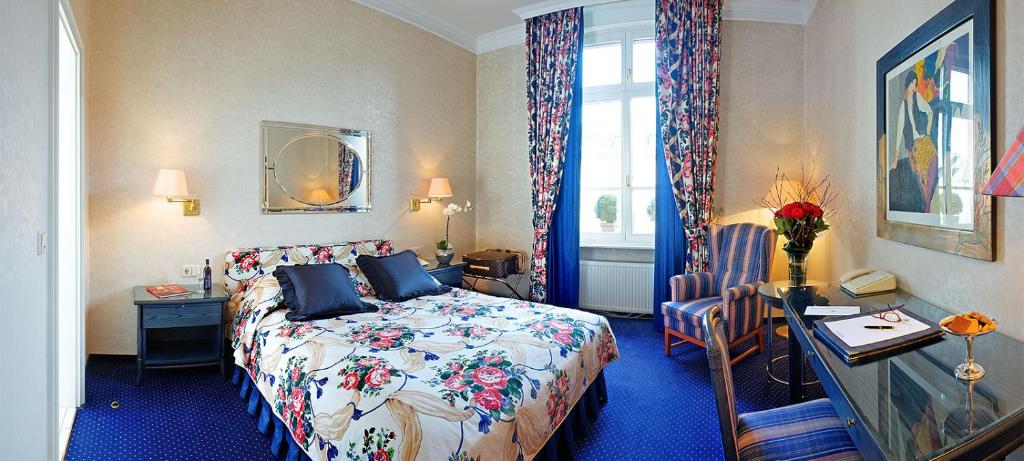 a bedroom with a bed and a desk and a window at Hotel Liebig in Frankfurt