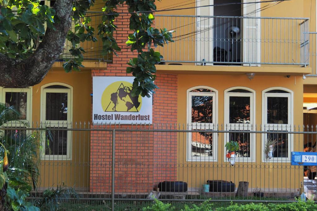 a building with a sign on the side of it at Hostel Wanderlust in Foz do Iguaçu