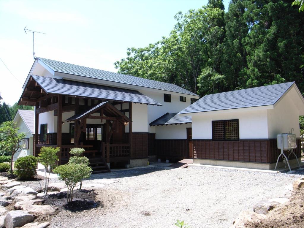 una casa blanca con techo negro en Cottage All Resort Service / Vacation STAY 8448, en Inawashiro
