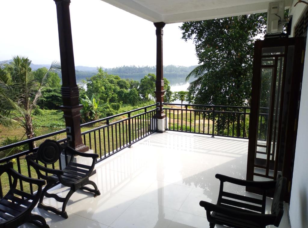 a balcony with two chairs and a view of the ocean at Lake Villa in Habaraduwa