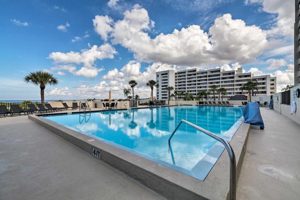 a large swimming pool with chairs and a building at Gulf Coast Escape with Balcony and Resort Amenities! in Hudson