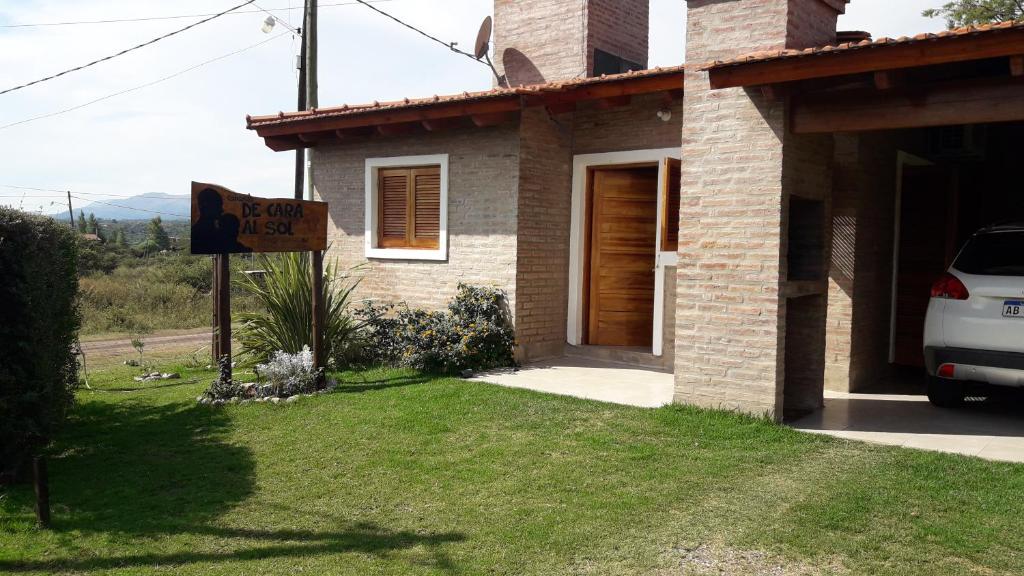 a house with a sign in front of it at Cabañas De Cara al Sol in Villa Giardino