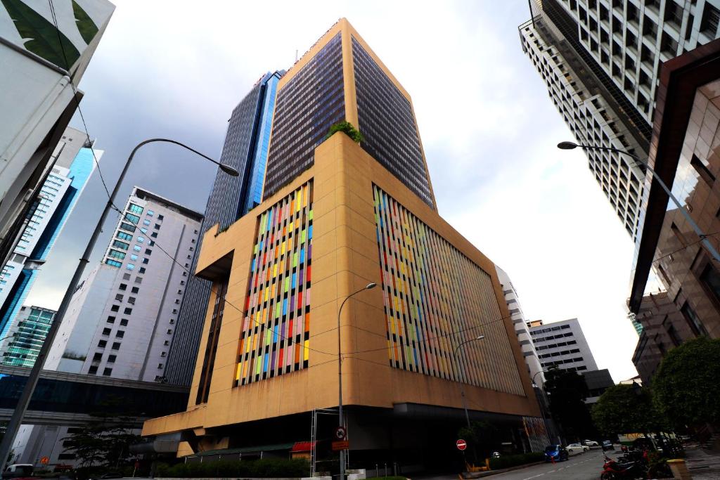 een hoog gebouw midden in een stad bij Hotel Grand Continental Kuala Lumpur in Kuala Lumpur