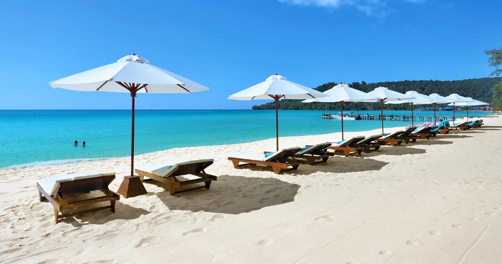 una fila de sillas y sombrillas en una playa en Sok San Beach Resort en Koh Rong Island