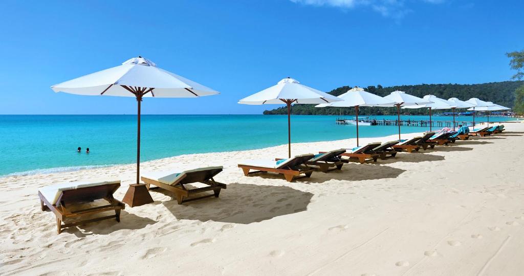 eine Reihe von Stühlen und Sonnenschirmen an einem Strand in der Unterkunft Sok San Beach Resort in Koh Rong
