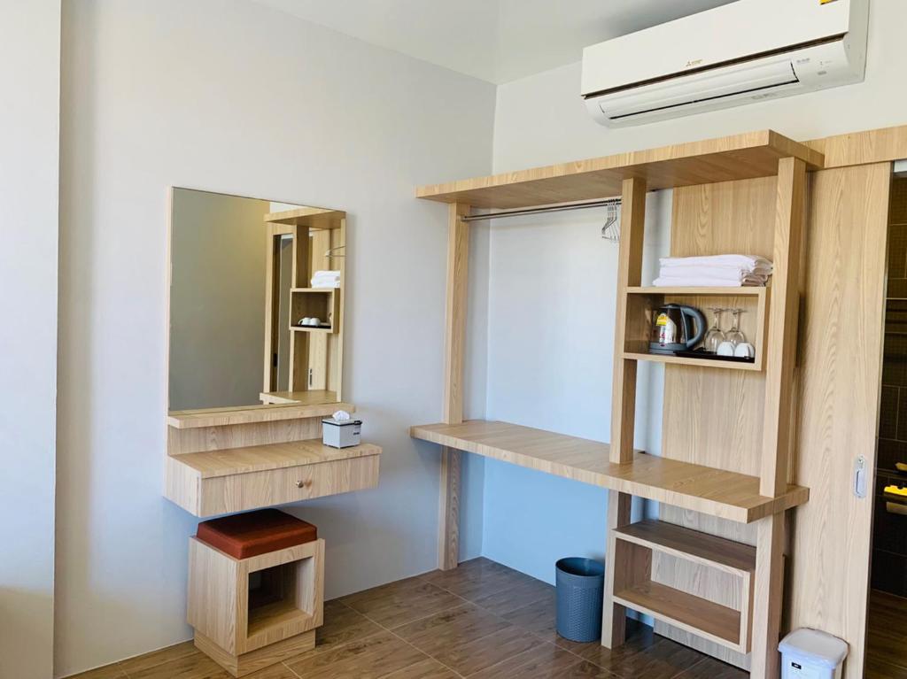 a room with wooden shelves and a mirror at Belong Boutique Luxury Hotel in Ban Wang Khon