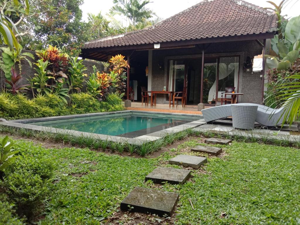 a swimming pool in the yard of a house at Dedik House in Ubud