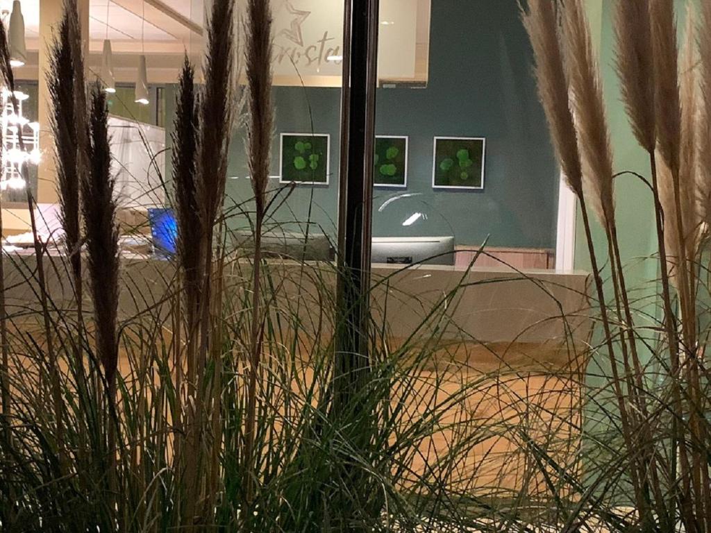 a room with some tall grass and paintings on the wall at Eurostar Hotel in Castrop-Rauxel