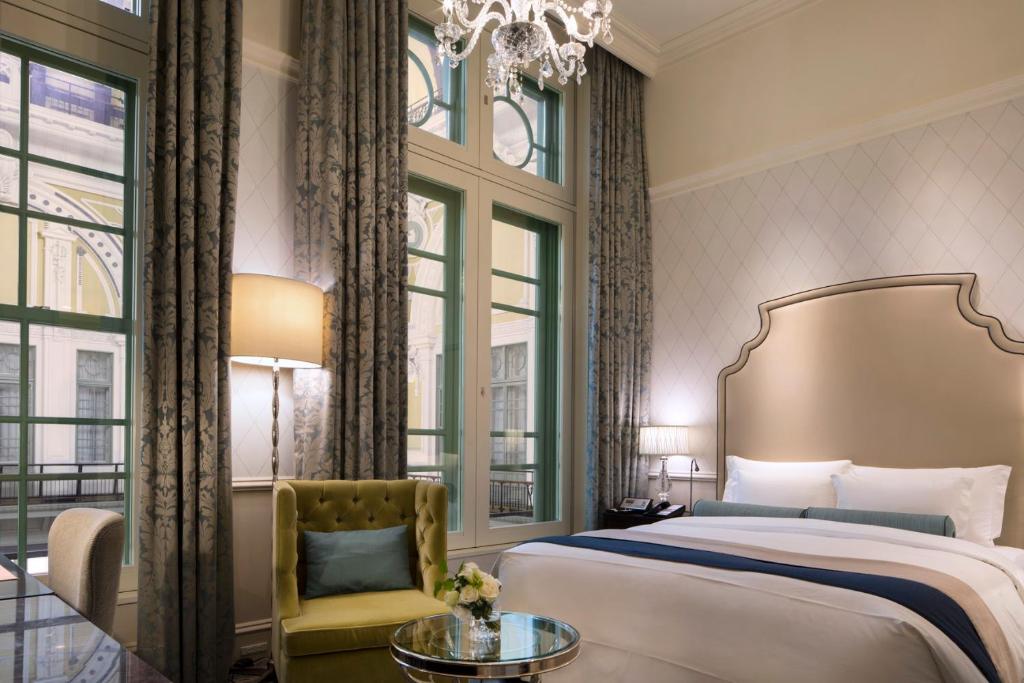 a bedroom with a bed and a chandelier at The Tokyo Station Hotel in Tokyo