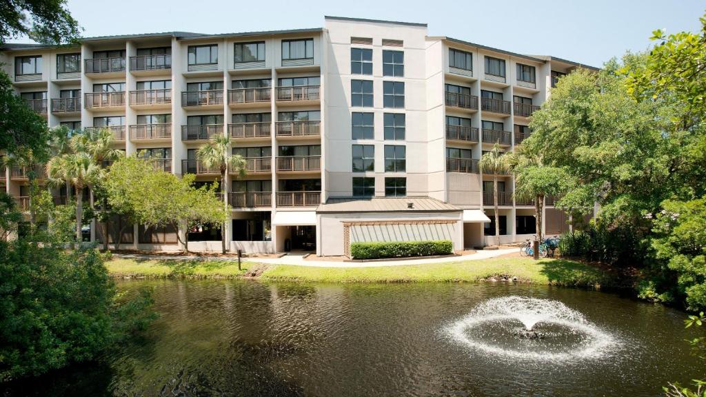 ein Apartmenthaus mit einem Teich davor in der Unterkunft Holiday Inn Express Hilton Head Island, an IHG Hotel in Hilton Head Island