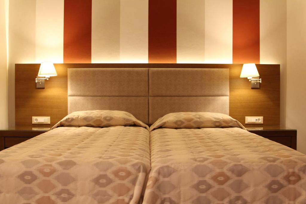 a bedroom with a large bed with two pillows at Achilles Hotel in Methoni