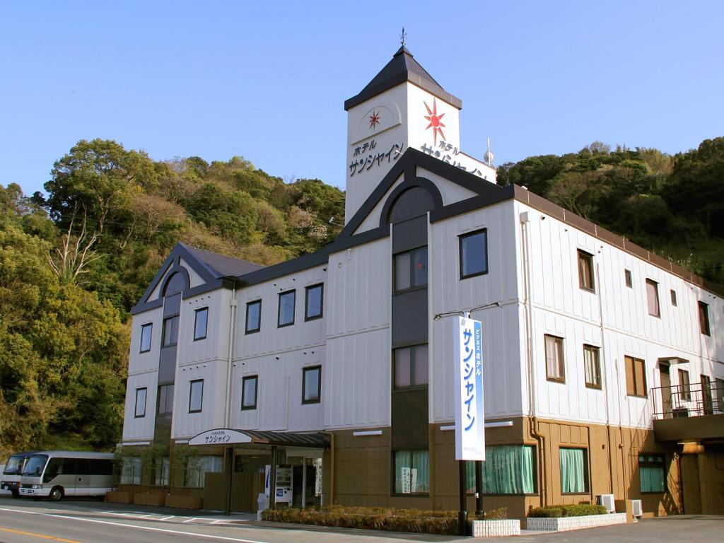有田的住宿－田川溫泉陽光酒店，一座建筑的顶部有一个钟楼