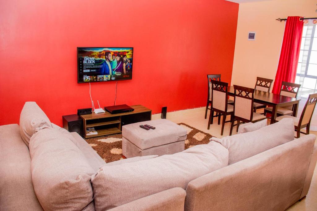 sala de estar con sofá y comedor en Beautiful and Homely en Eldoret