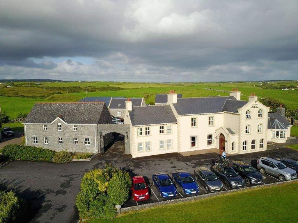 una vista aérea de una gran casa blanca con coches aparcados en Aran View Country House, en Doolin