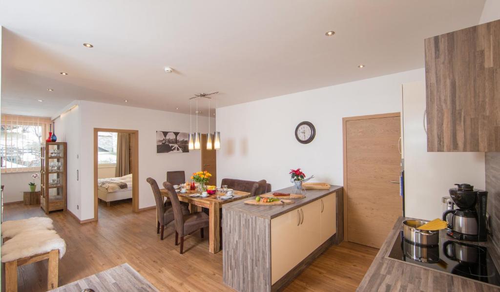 kuchnia i salon ze stołem i krzesłami w obiekcie Appartement Living Schönwies including Zell am See-Kaprun summercard w mieście Zell am See