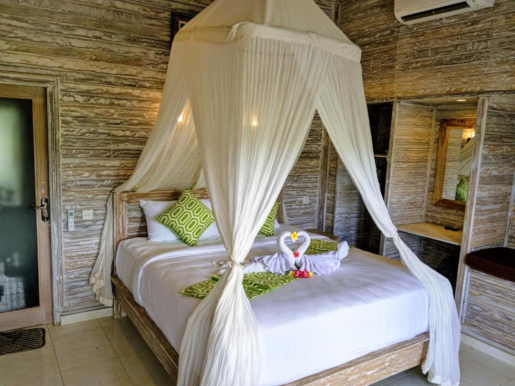 a bedroom with a bed with a canopy at Mesari Hut Lembongan in Nusa Lembongan