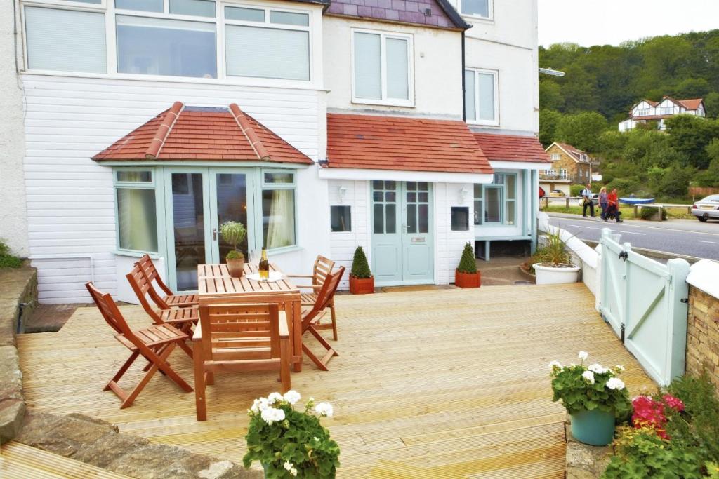a wooden deck with a table and chairs on a house at East Row Lodge in Whitby