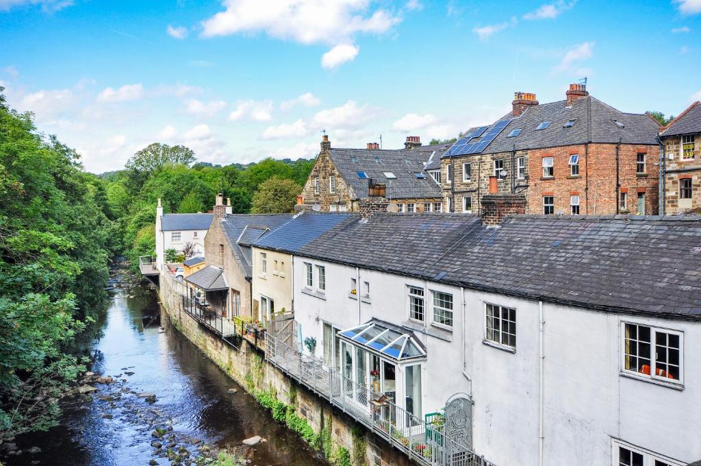 a group of buildings next to a river at Esk View Cottage in Grosmont