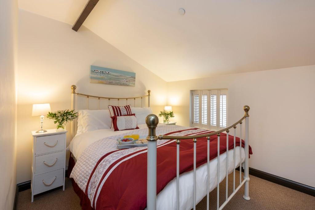 a bedroom with a bed with a red and white blanket at Rose Cottage, Filey in Filey