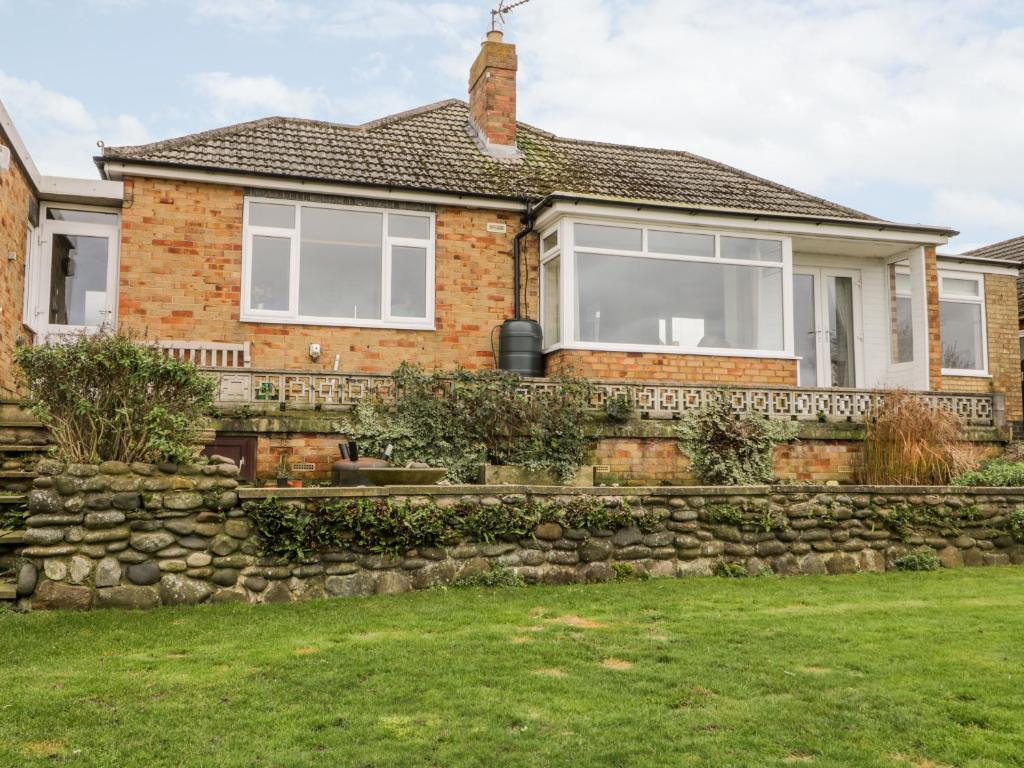 a brick house with a stone retaining wall at 8 Mere View Avenue in Hornsea