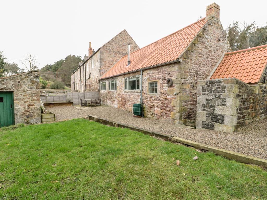 an old stone building with a yard in front of it at The Old Workshop in Belford