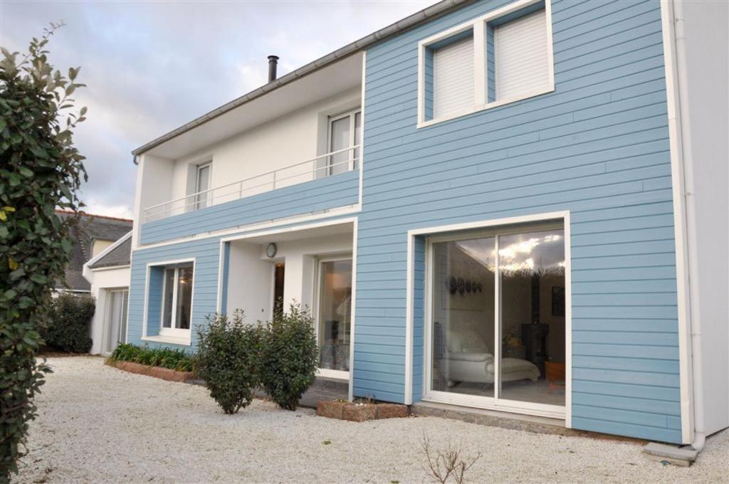 une maison bleue et blanche avec une grande fenêtre dans l'établissement Maison 4 personnes à 100m de la plage de la Grève Rose à TREGASTEL - Ref 142, à Trégastel
