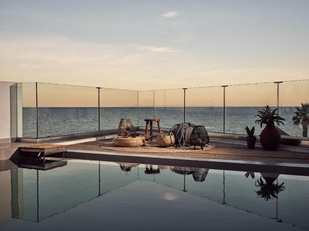 a swimming pool with a view of the ocean at Oceanis Luxury Suites in Kypseli
