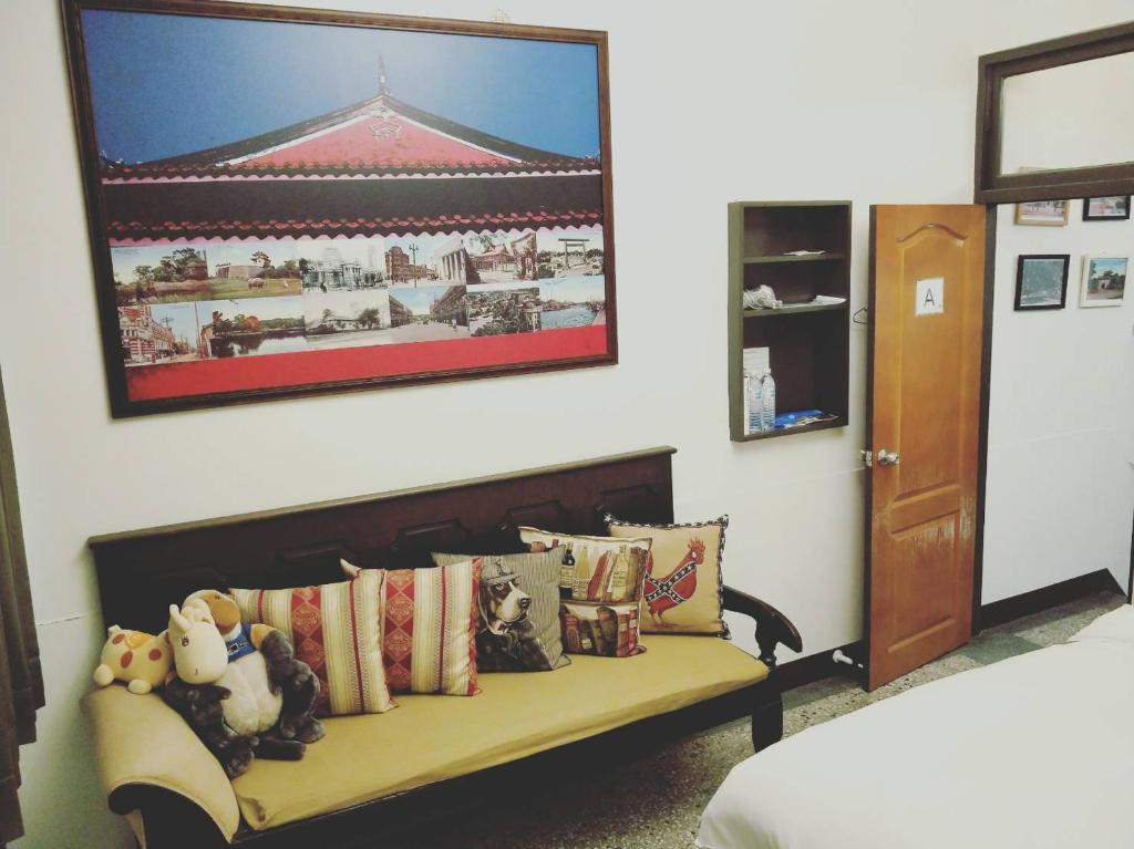 台南的住宿－民生綠園，客房设有带枕头的沙发,墙上挂着一幅画