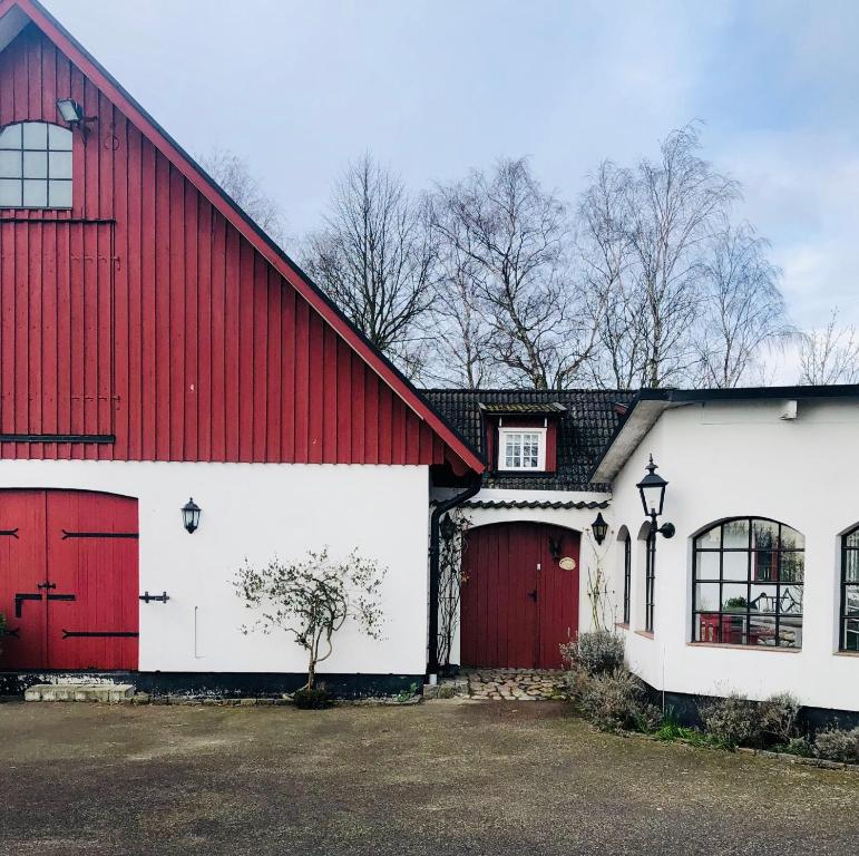 un granero rojo y blanco con garaje rojo y blanco en Stort rymligt boende med två sovrum och pentry i lantlig miljö en Höllviken