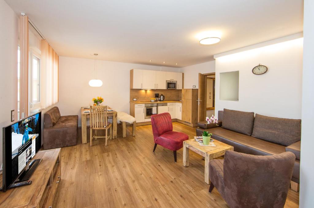 salon z kanapą i stołem w obiekcie Appartement Living Schönwies including Zell am See-Kaprun summercard w mieście Zell am See