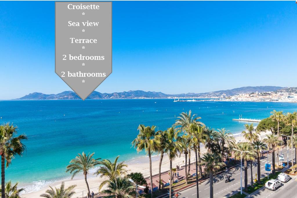 une vue sur une plage avec des palmiers et l'océan dans l'établissement On la Croisette: luxe 2 bedrooms/ 2 baths, à Cannes