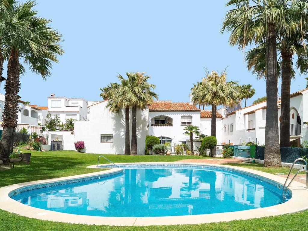una piscina frente a una casa con palmeras en Holiday Home Villas de Madrid by Interhome, en Estepona