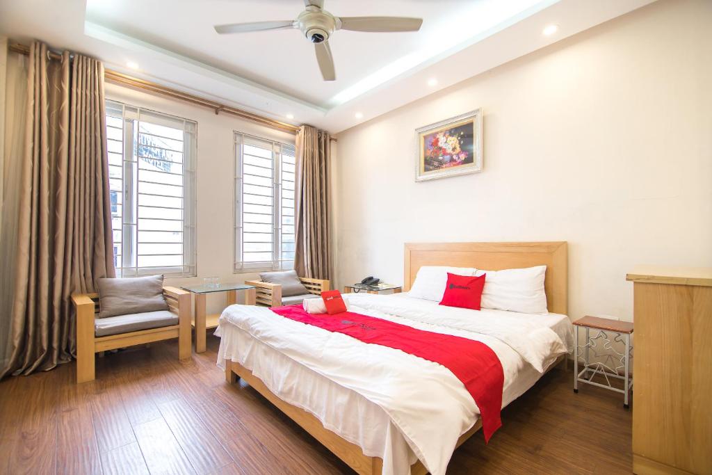 a bedroom with a large bed with a red blanket at RedDoorz Newstyle Apartment Tran Duy Hung in Hanoi