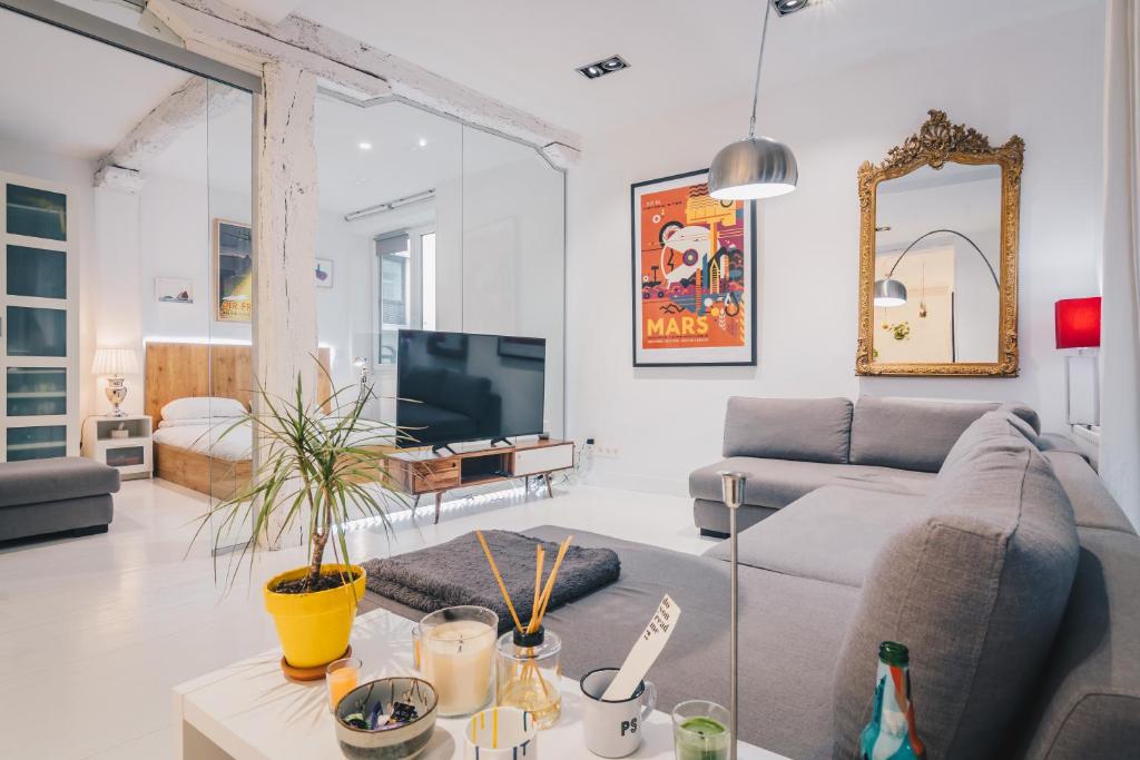uma sala de estar com um sofá e uma televisão em Plaza Nueva apartment by People Rentals em Bilbao