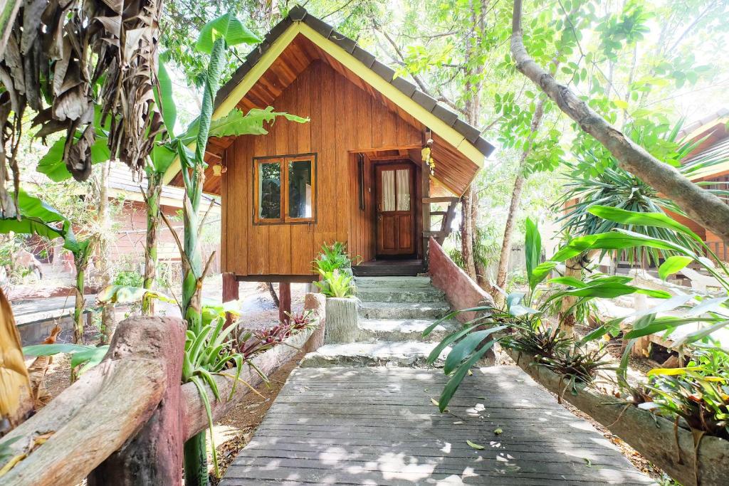 un chemin en bois menant à une cabine dans une forêt dans l'établissement OYO 604 Ruen Mai Horm Resort, à Trang