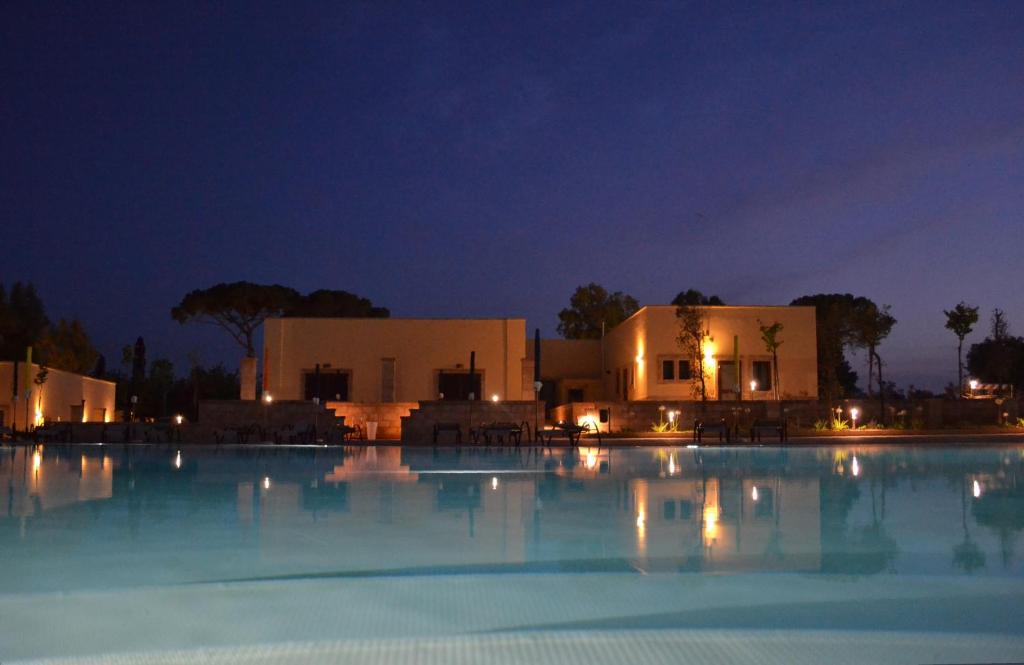 duży basen przed budynkiem w nocy w obiekcie Lu Panaru w mieście Lecce