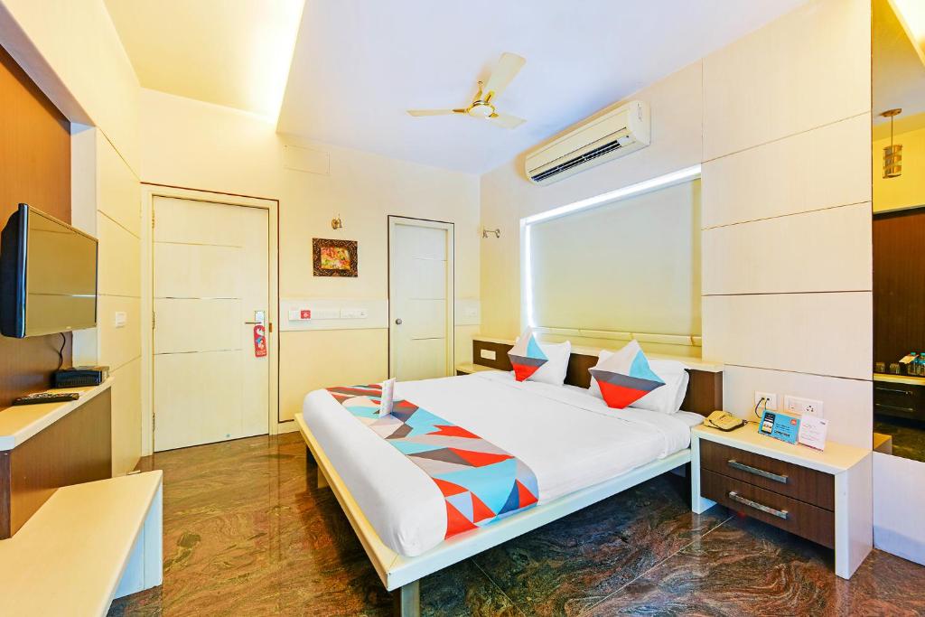 a bedroom with a large bed and a desk at FabExpress B Zone in Chennai