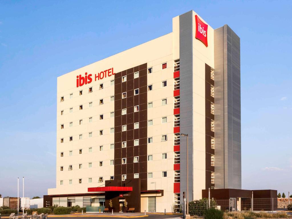 een hotelgebouw met een groot bord bij Ibis Juarez Consulado in Ciudad Juárez