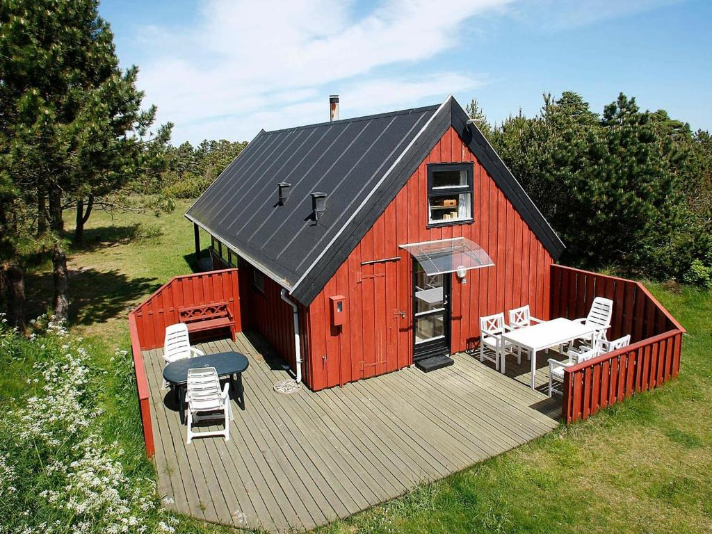 Kandestederneにある7 person holiday home in Skagenの赤い納屋(デッキ、テーブル、椅子付)