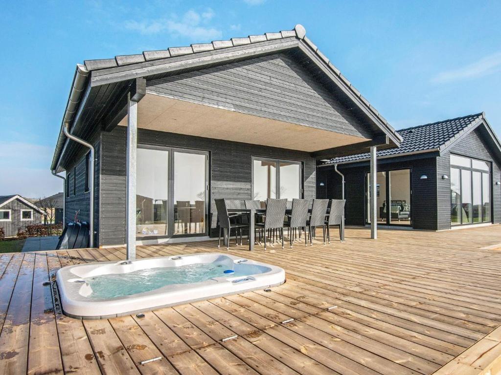 a hot tub on a wooden deck with a house at 12 person holiday home in Haderslev in Haderslev