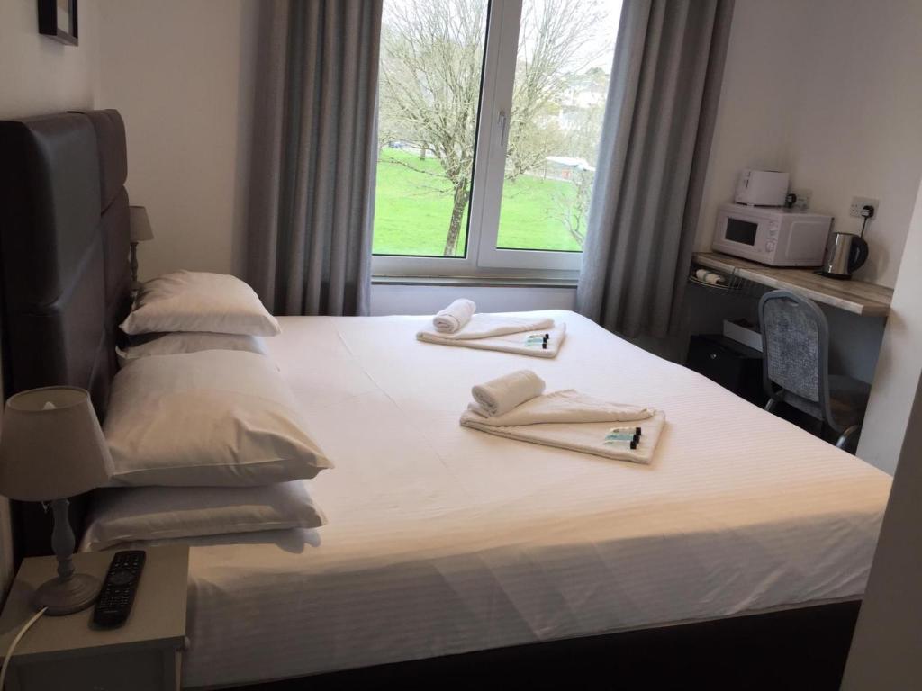 une chambre à l'hôpital avec un lit et des serviettes. dans l'établissement The Lake House, à Plymouth