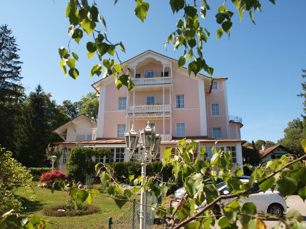 un gran edificio rosa con patio en Hotel Villa Sisi en Pöcking