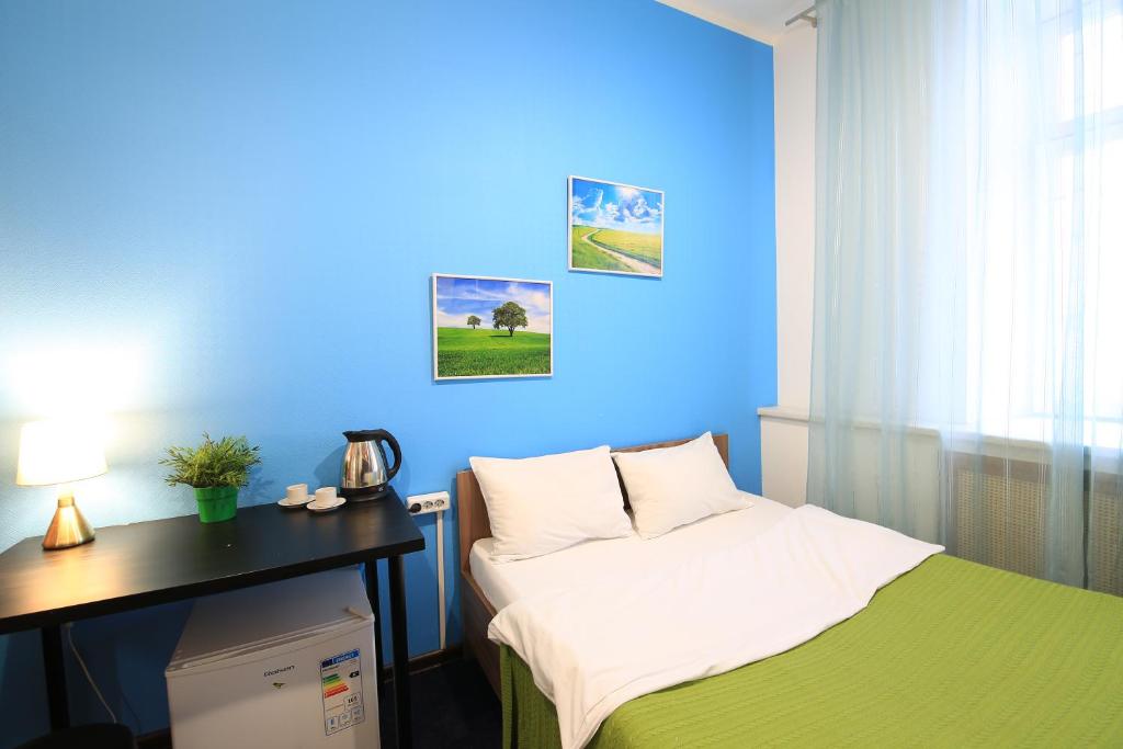 a room with a bed with a blue wall at Hostel Cinema Moscow Хостел Синема in Moscow