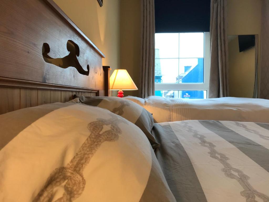 une chambre d'hôtel avec 2 lits et une tête de lit en girafe dans l'établissement Ashes Seafood Restaurant Accommodation, à Dingle