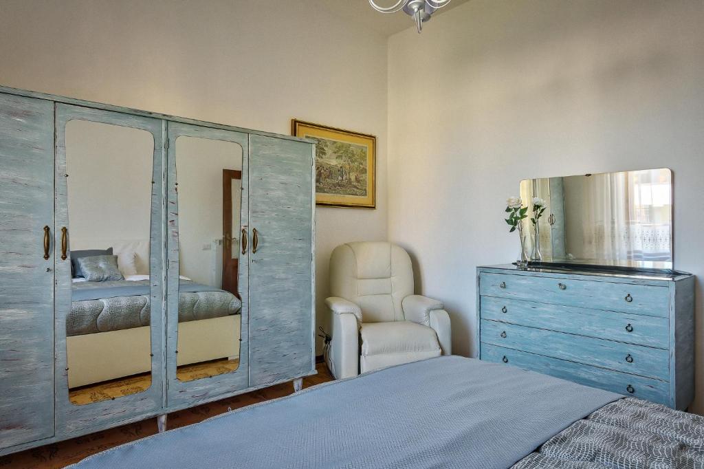 a bedroom with a dresser and a bed and a mirror at Appartamento Irma in Sinalunga